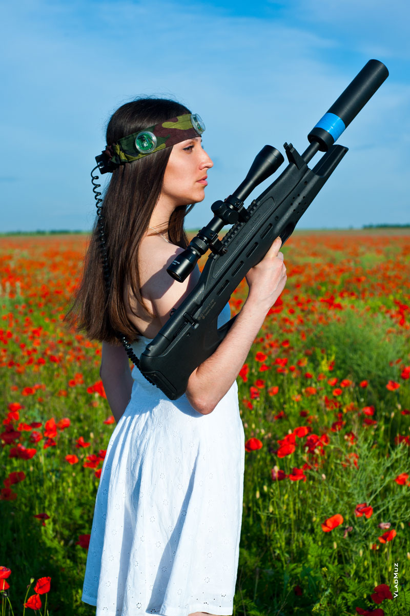 Фотография девушки в белом платье с черной винтовкой