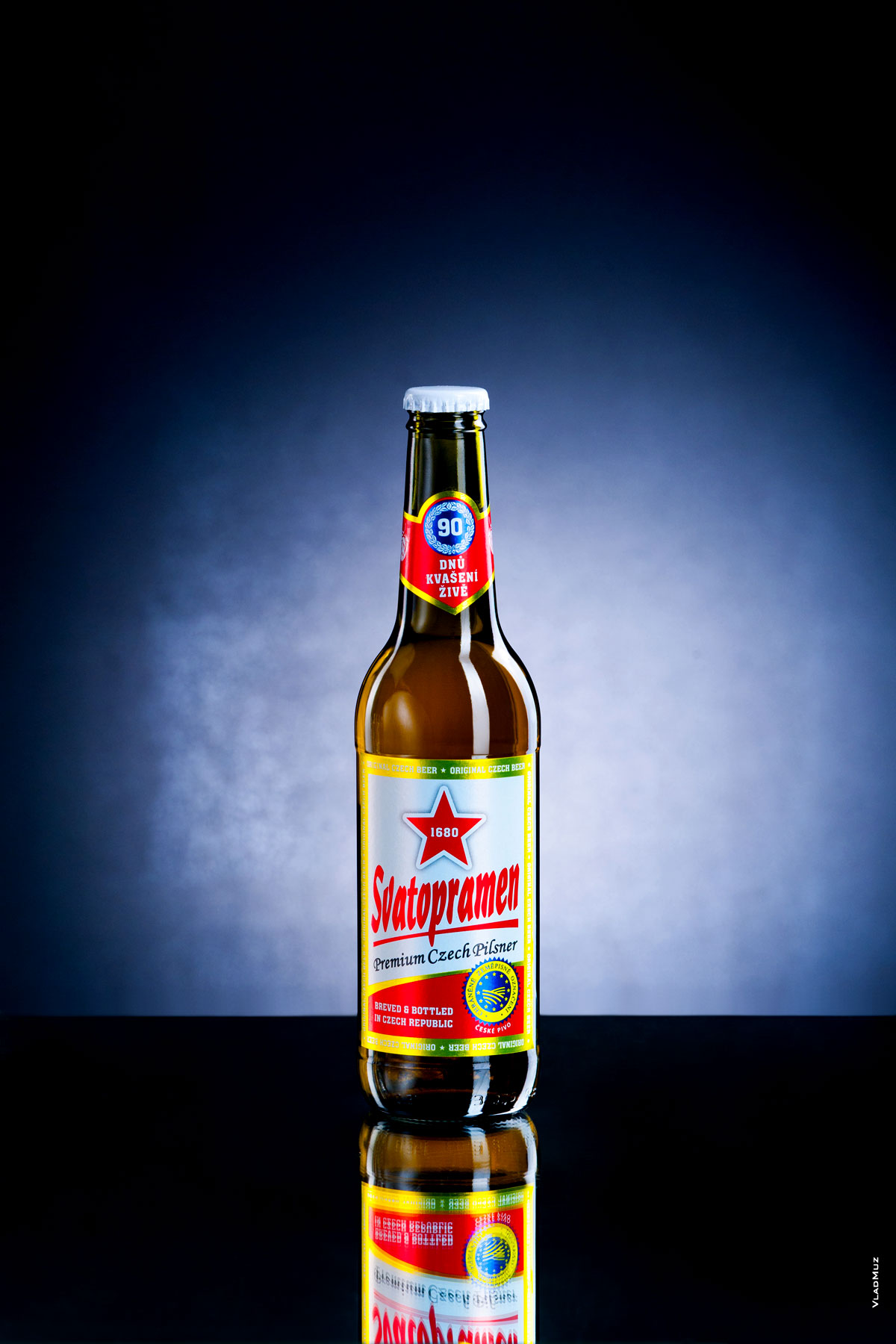 Фото бутылки светлого пива «Святопрамен» на темно-синем фоне