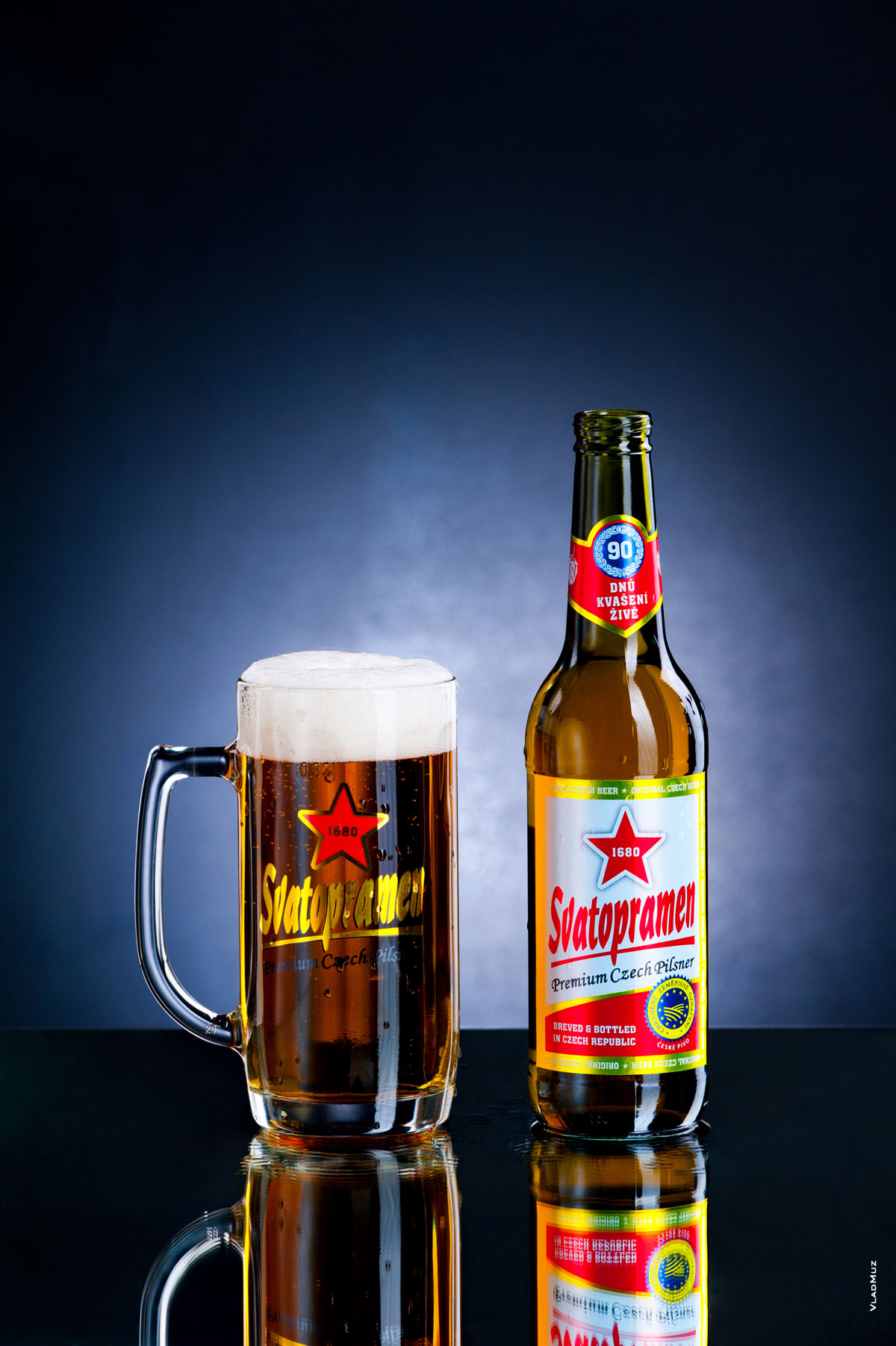 Фото бокала с пивом и бутылки пива «Святопрамен» на темно-синем фоне