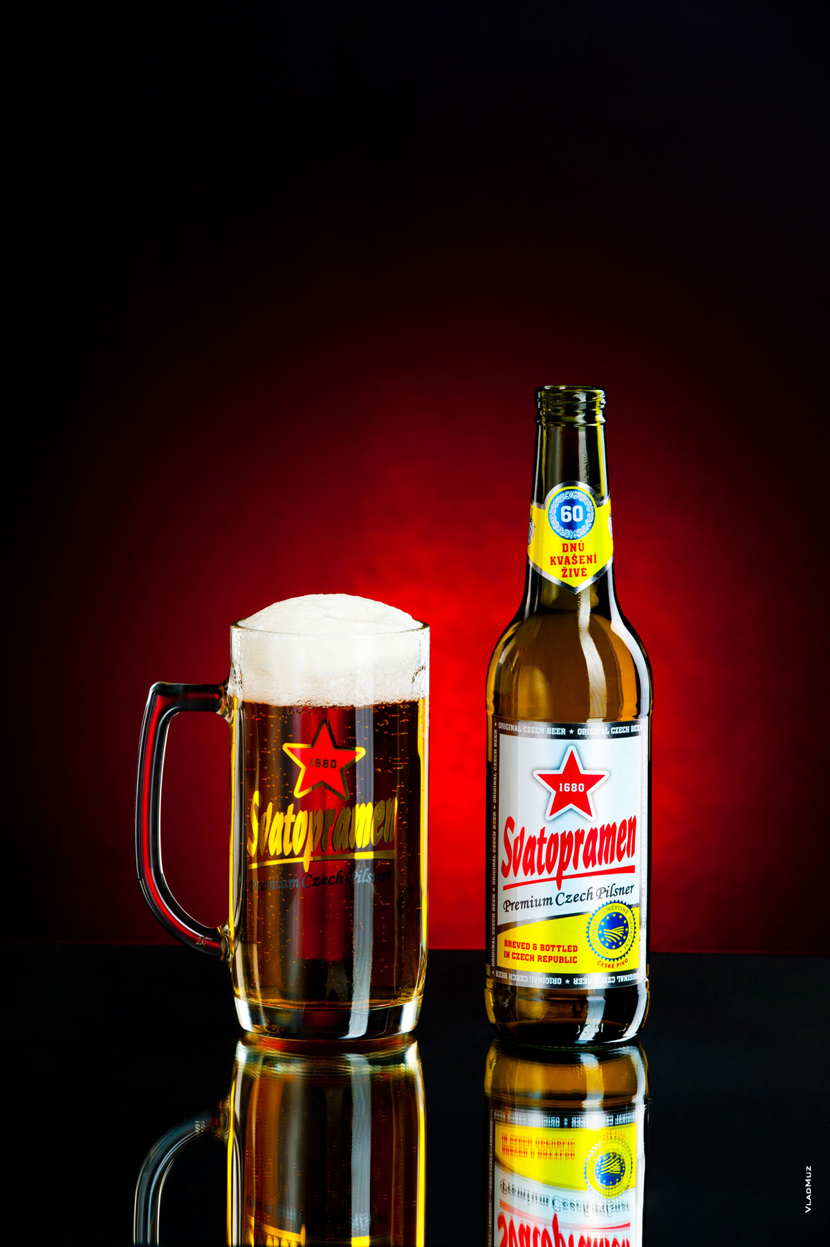 Фото светлого пива «Святопрамен» в бокале и в бутылке на темно-красном фоне
