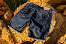 Фото джинсовых мужских шорт, лежащих на камне