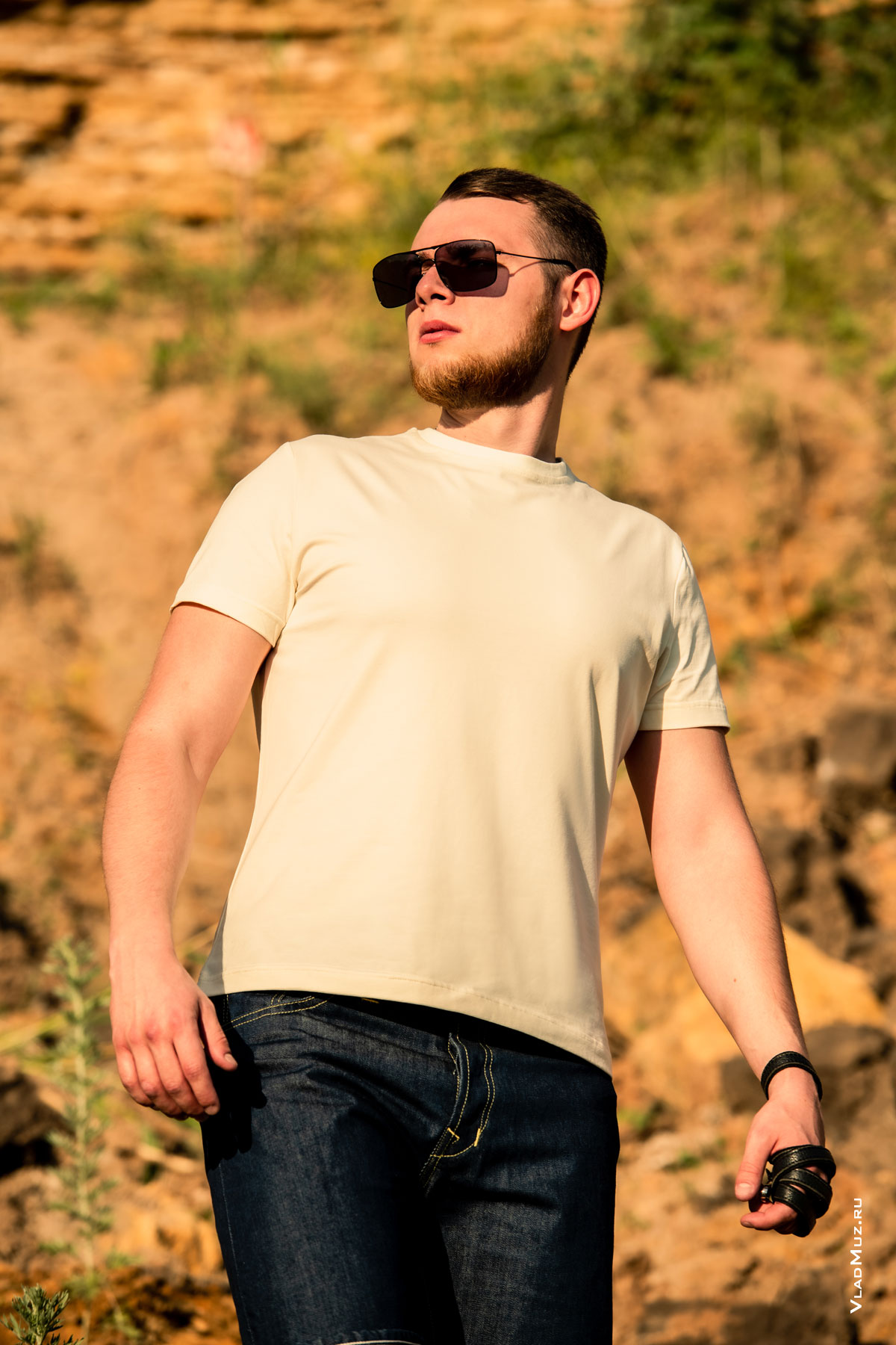 Поясное фото мужчины в солнечных очках, в шортах и футболке, на фоне карьера, для рекламы бренда Woodcutter