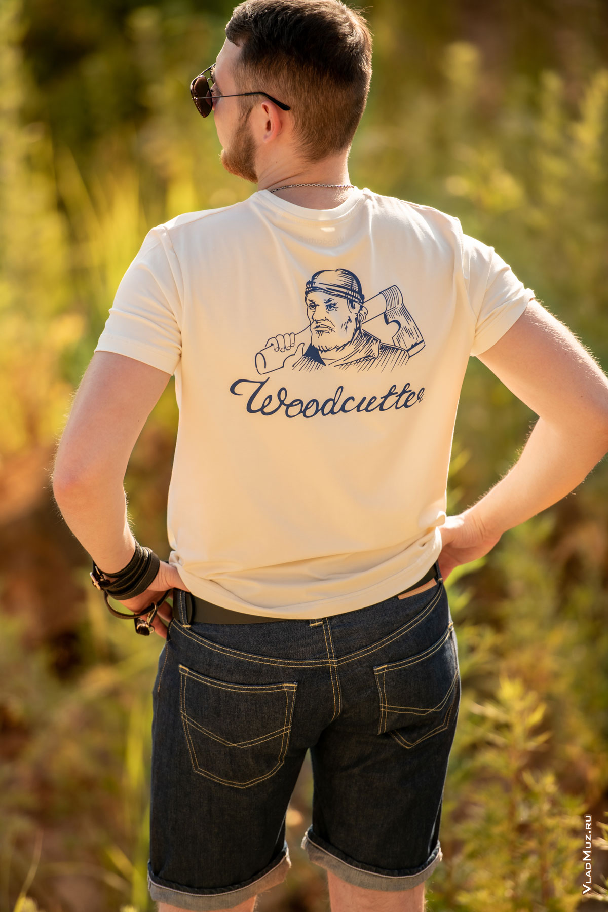Фото мужчины в шортах и футболке с логотипом Woodcutter на фоне природы