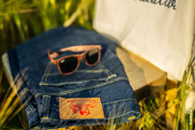 Фото солнцезащитных очков и джинсов Woodcutter на стуле