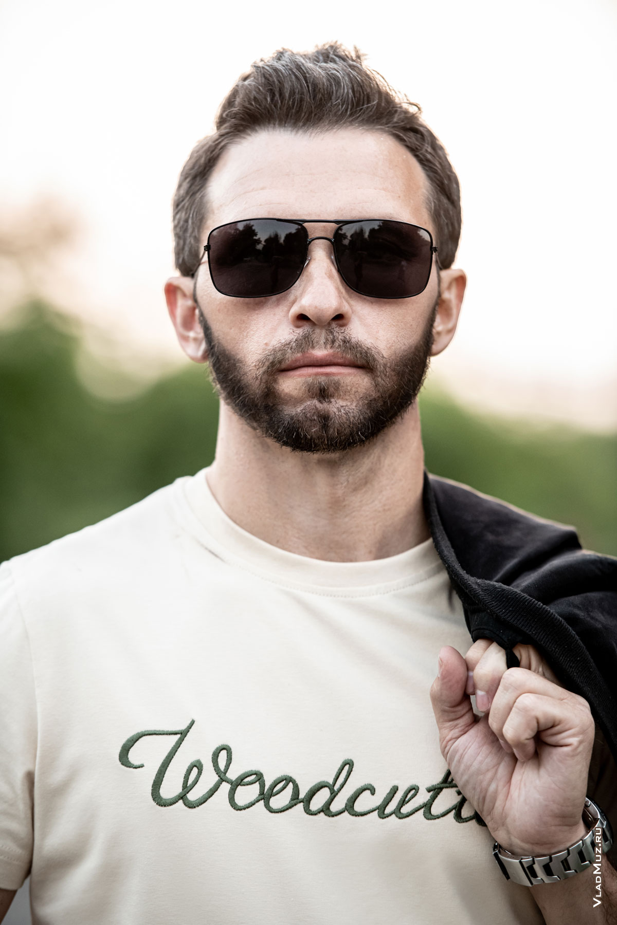 Грудной рекламный фотопортрет мужчины в солнцезащитных очках и светло-бежевой футболке Woodcutter