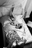 Эротическая фотография обнаженной девушки, лежащей на кровати, вид сверху
