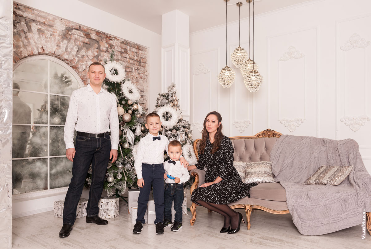 Новогоднее фото семьи с 2-мя детьми в студии на фоне новогодних елок