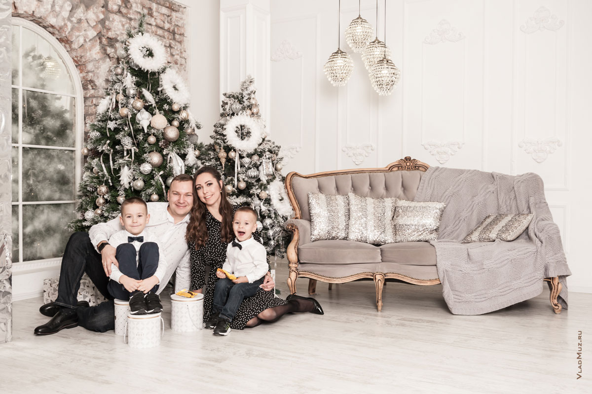 Семейное фото в студии с 2-мя детьми на фоне новогодних ёлок