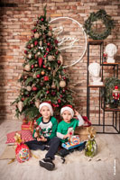 Новогоднее фото 2-х мальчиков с подарками на фоне новогодней ёлки
