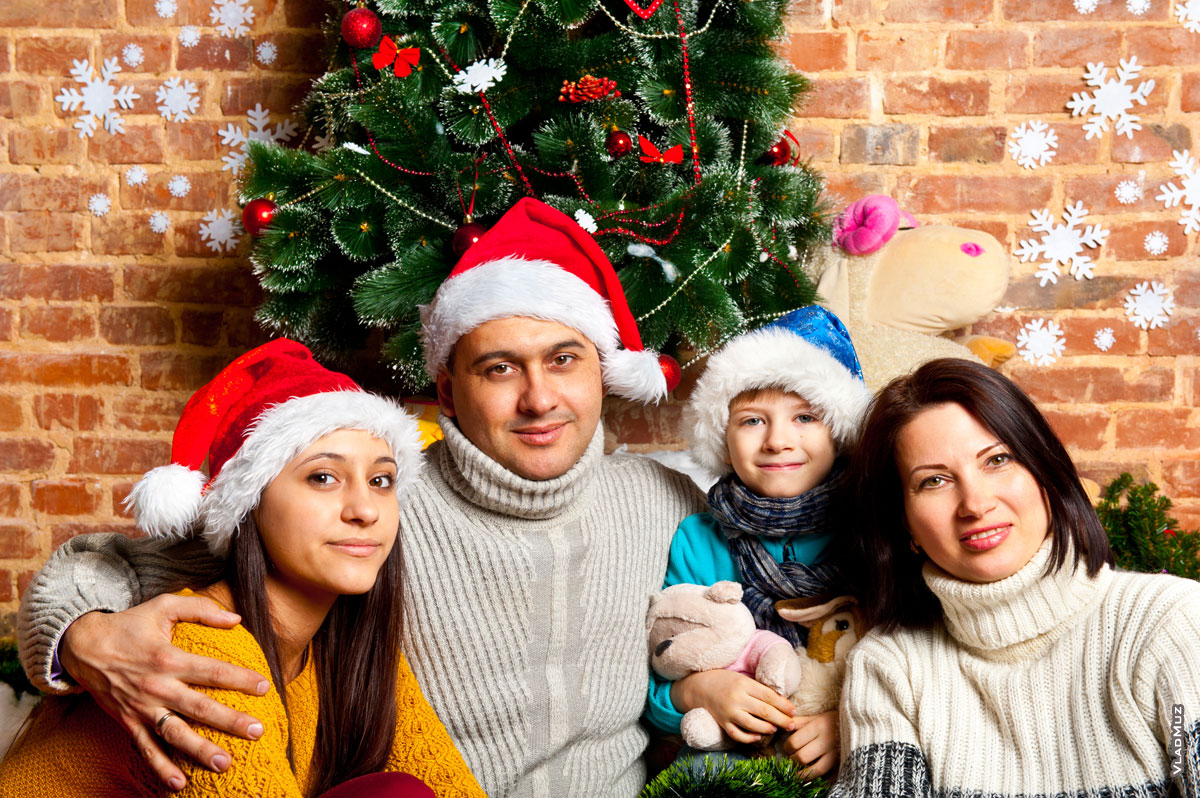 Семейное новогоднее фото у елки крупным планом