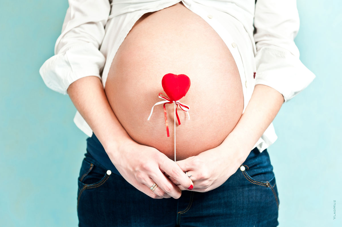 Фото красного сердца на фоне живота беременной девушки