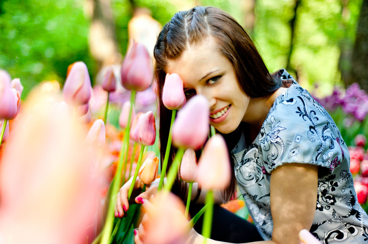 Фото девушки, которая прячется в тюльпанах ботанического сада