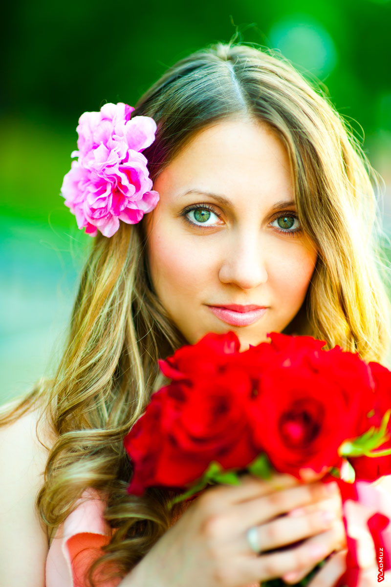 Фотопортрет девушки с цветком в волосах и с букетом красных роз