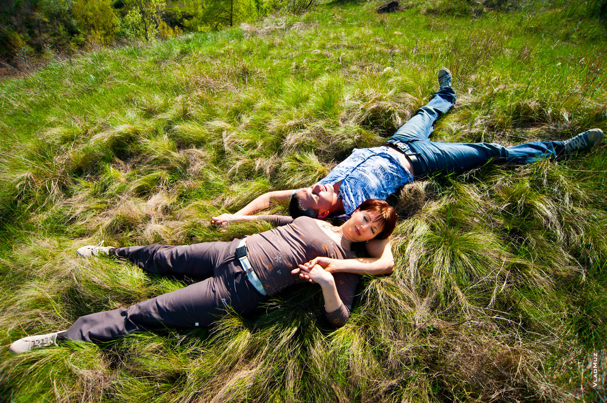 Фото молодой пары влюбленных, лежащих на траве