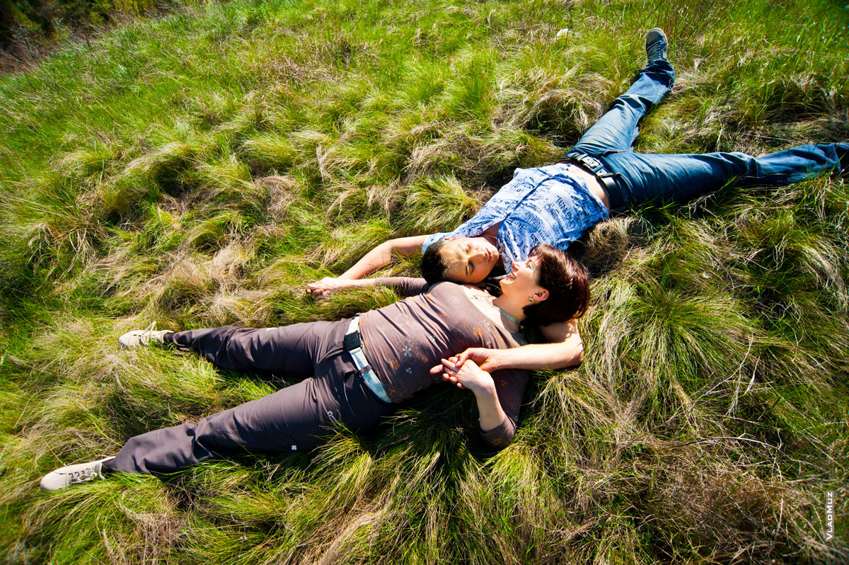Романтическое фото влюбленных, лежащих на траве (вид сверху)
