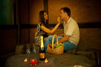 Начало романтической фотосессии: влюбленная пара при свечах с фруктами и шампанским