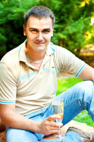 Фотопортрет мужчины с бокалом шампанского на лужайке