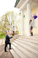 Фото мужчины с букетом цветов перед лестницей Дворцового павильона и стоящей у колонны девушки