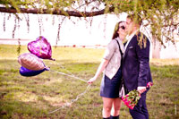Фото влюбленной пары под деревом: девушка с воздушными шарами и мужчина с букетом алых роз