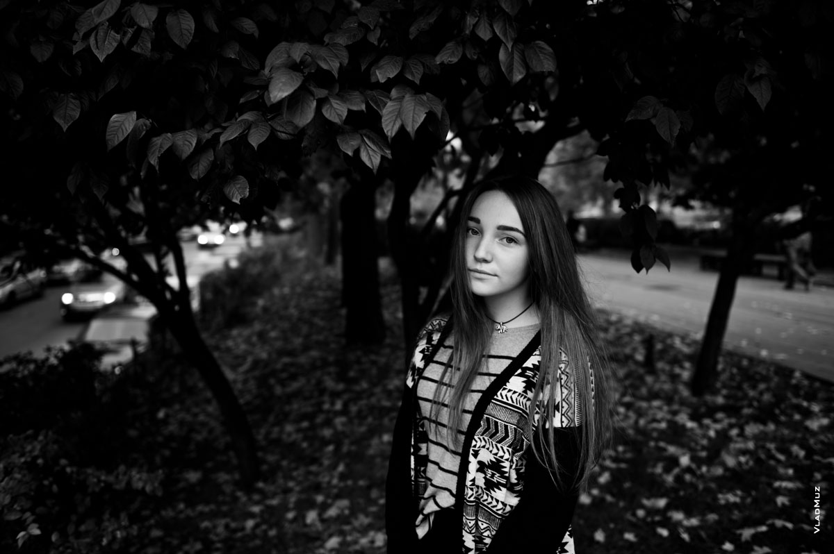 Черно-белый фотопортрет девушки на фоне из листвы дерева