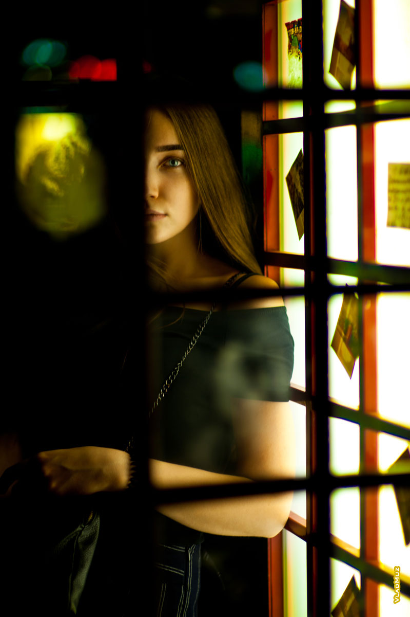 Фото лица девушки сквозь стекла и раму двери