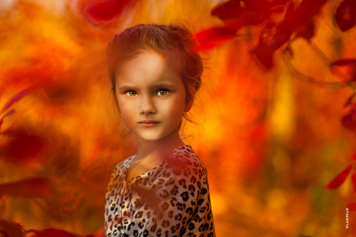 Осеннее портретное фото девочки среди красно-желтых листьев