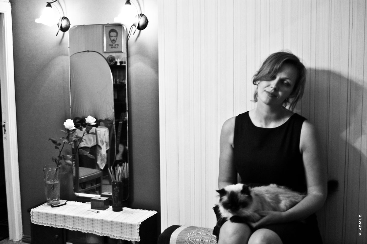 Черно-белое фото девушки с кошкой в квартире и отражение доктора Хауса в зеркале