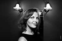 Черно-белый женский жанровый фотопортрет в квартире на фоне горящих ламп бра