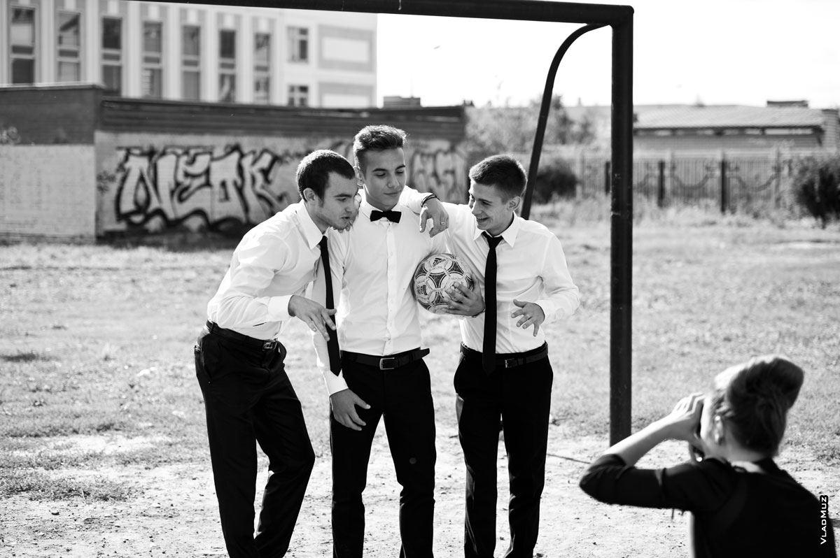 Жанровый фотопортрет 3-х юношей в белых рубашках с галстуками, с футбольным мячом на воротах