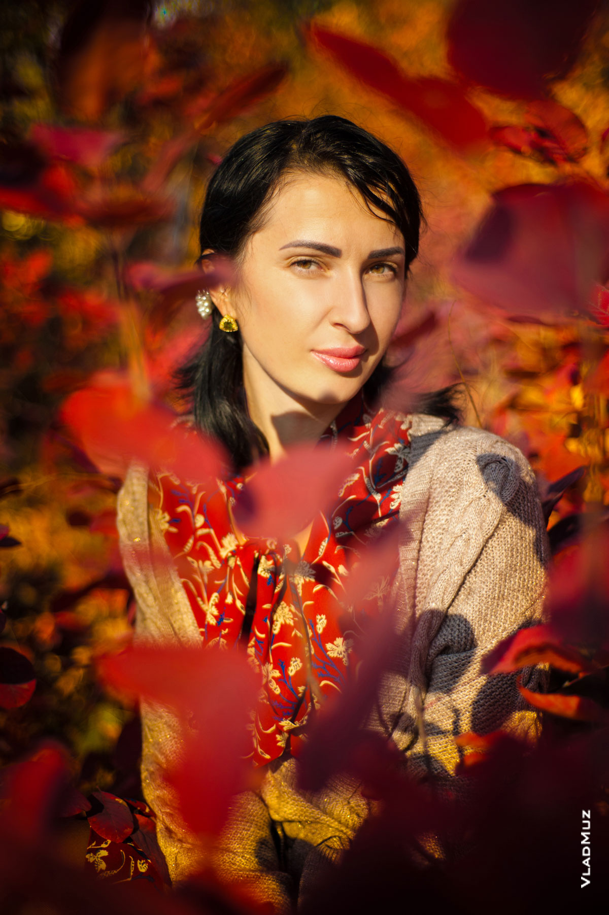Яркий осенний фотопортрет девушки среди красных листьев