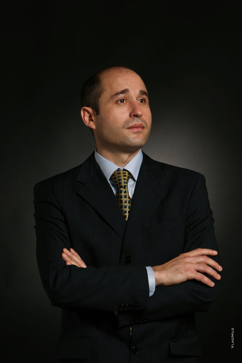 Классический деловой поясной фото портрет мужчины в костюме в студии, на черном фоне