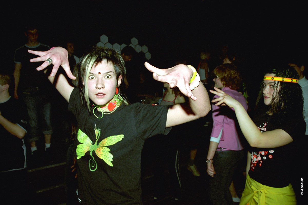 Фото танцующей в ночном клубе девушки с принтом стрекозы на майке
