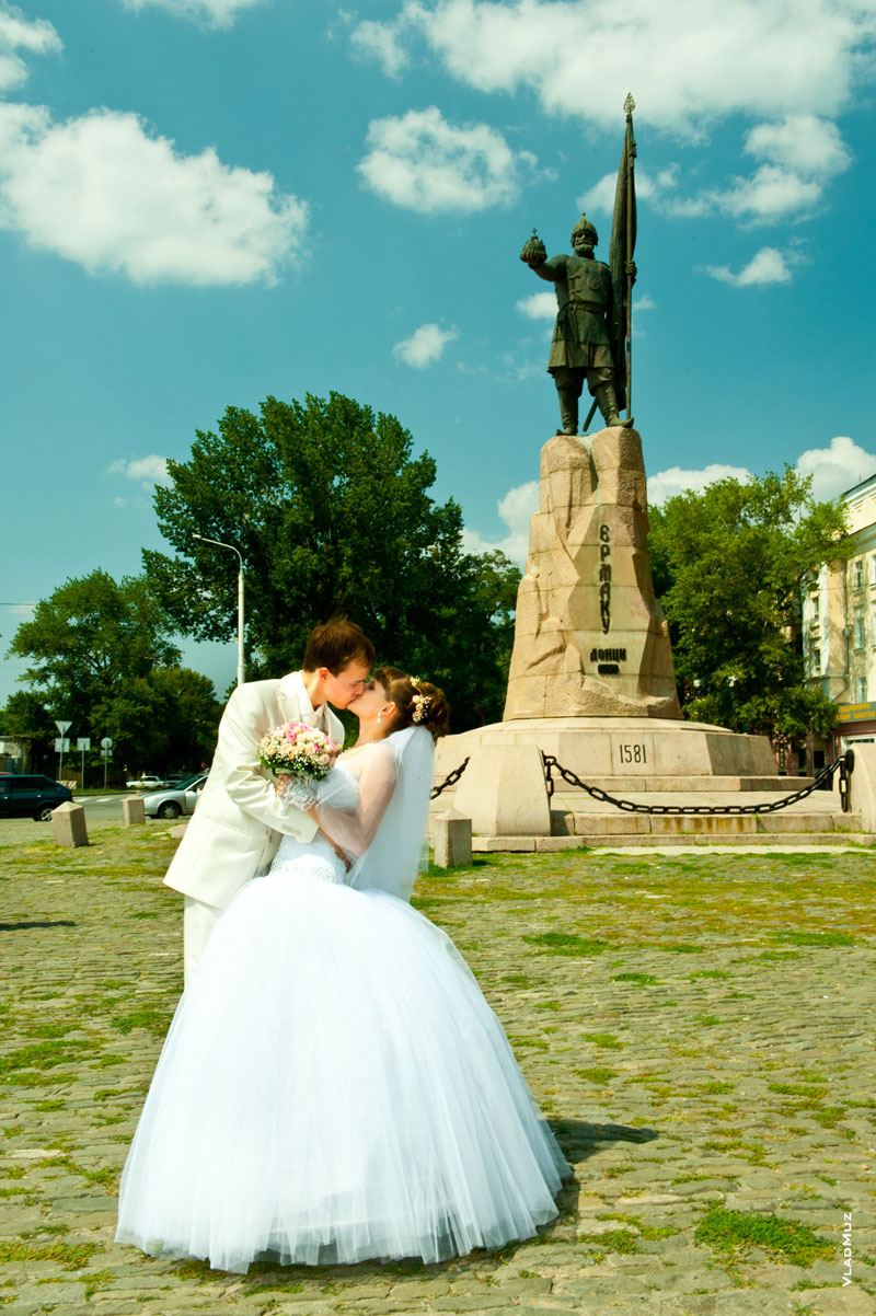 Фото свадебного поцелуя новобрачных на фоне памятника Ермаку в Новочеркасске