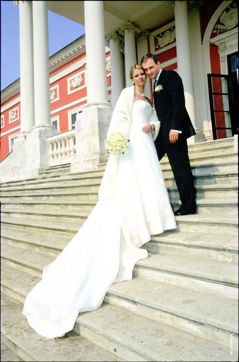 Фотография жениха, невесты и ее свадебного платья на ступенях усадьбы Кусково в Москве
