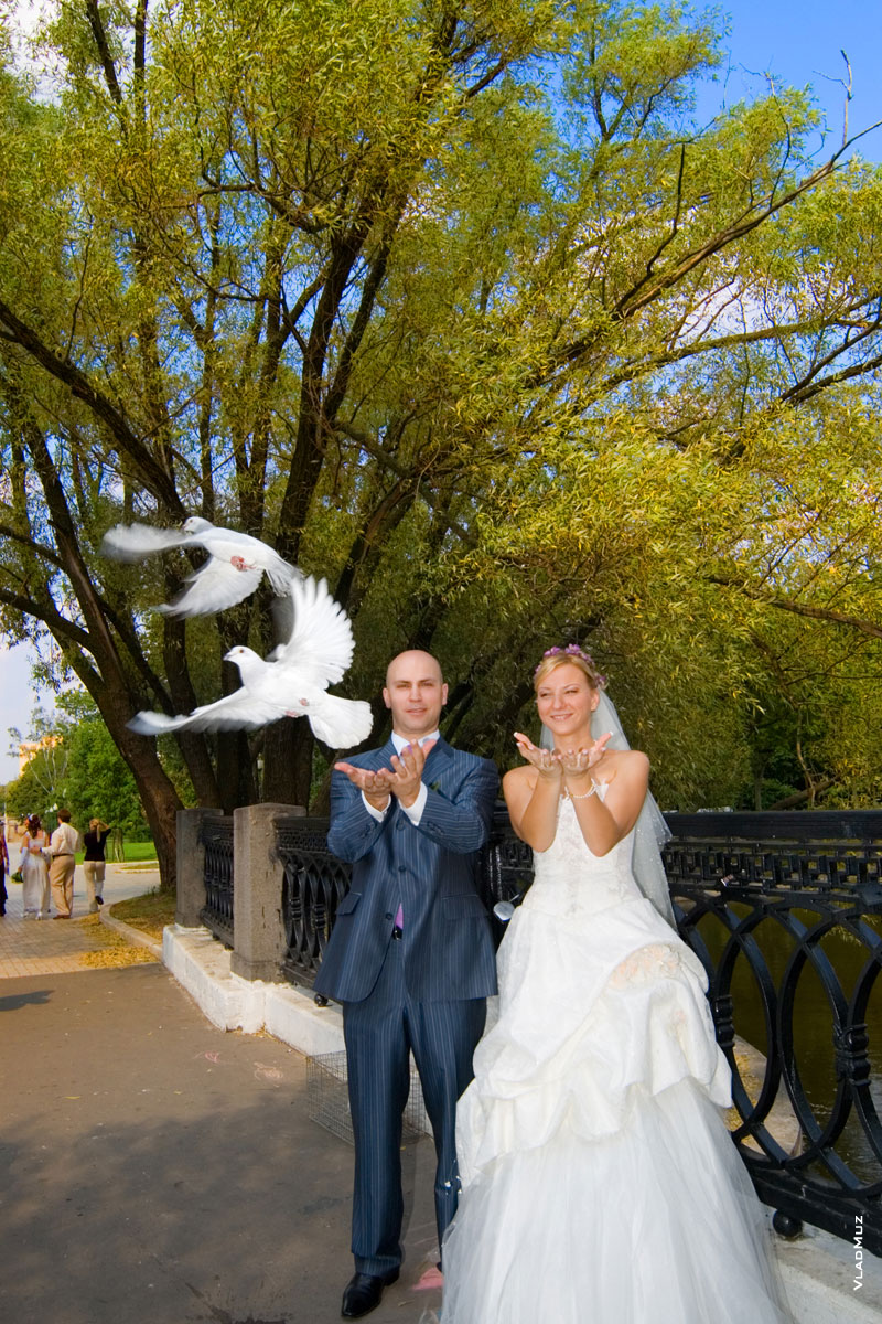 Фото жениха с невестой, отпускающих белых голубей у Новодевичьего монастыря в Москве