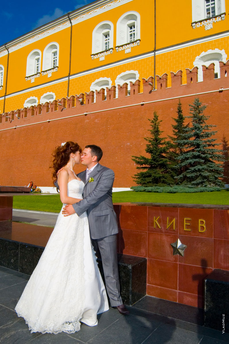 Фото свадебной пары на аллее городов-героев у Кремлевской стены рядом с гранитным блоком Киева