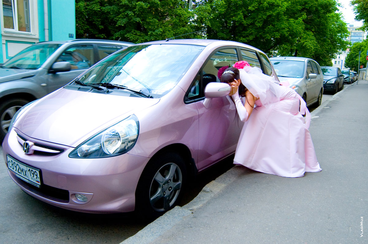 Автомобиль невесты: девушка прихорашивается перед зеркалом заднего вида