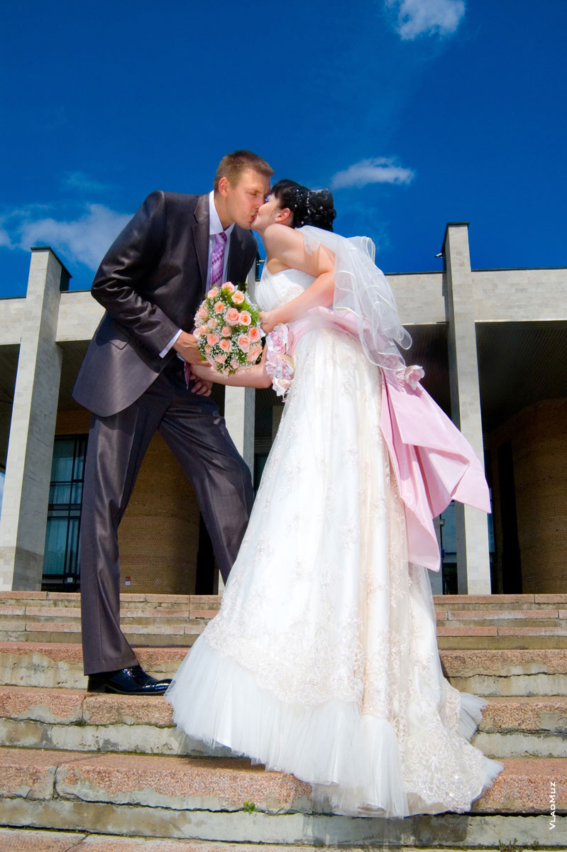 Фото свадебного поцелуя новобрачных на лестнице перед Дворцом культуры «Яуза» в Мытищах