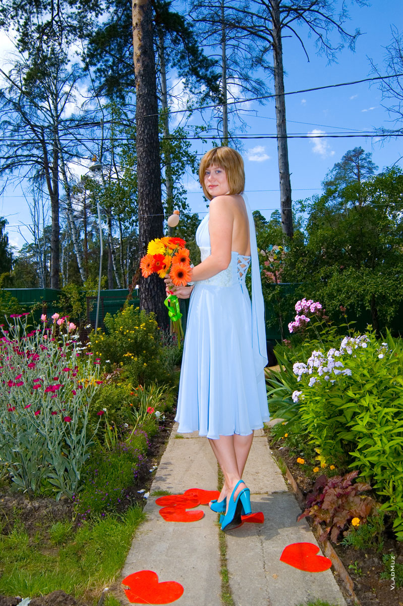 Фото невесты в голубом платье с цветами и алыми сердцами под ногами