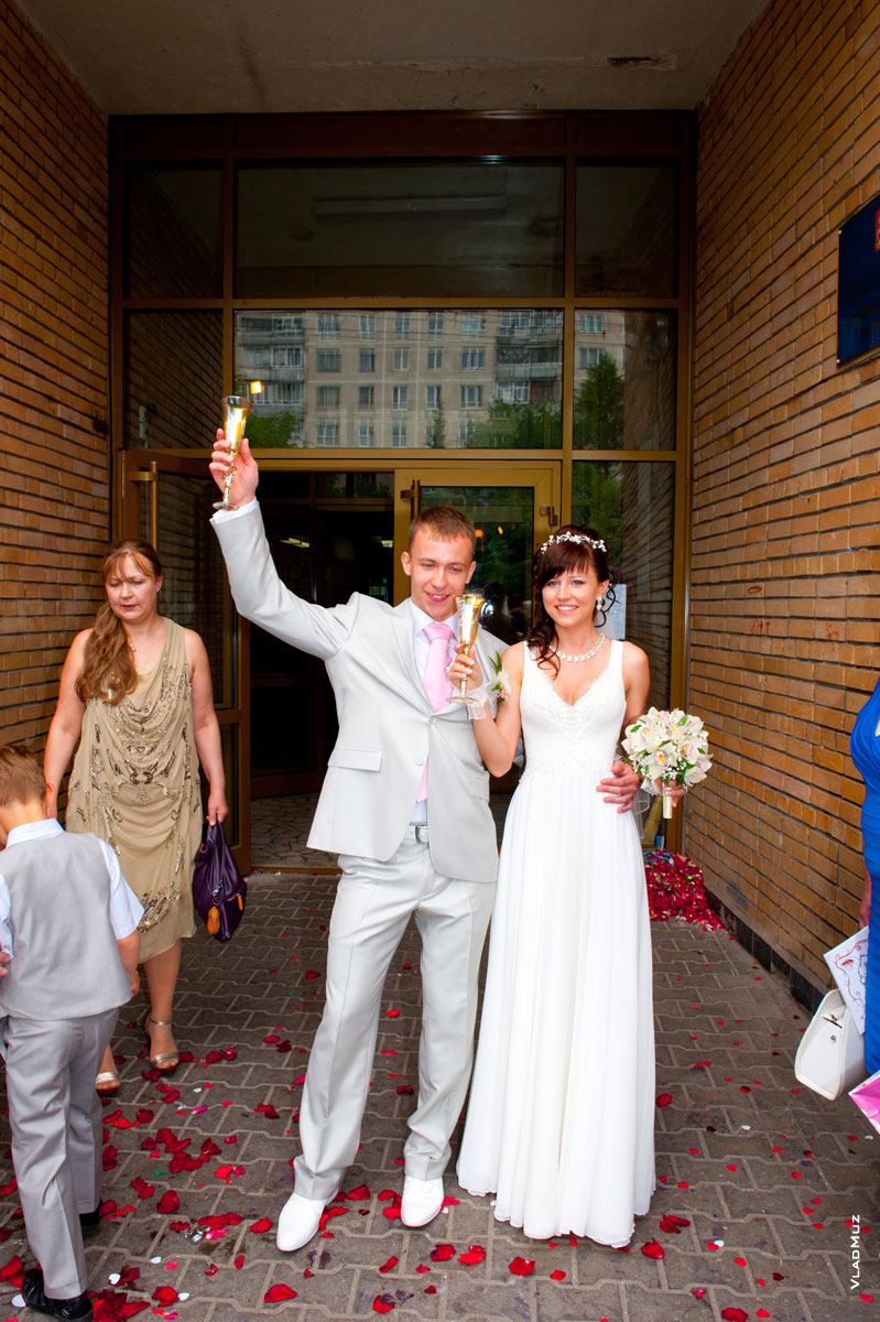 Жених и невеста пьют шампанское и бьют бокалы перед ЗАГСом г. Королёва