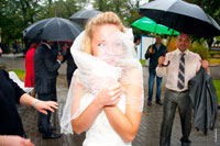 Экстремальная фотография замерзшей невесты в свадебной фате в дождь