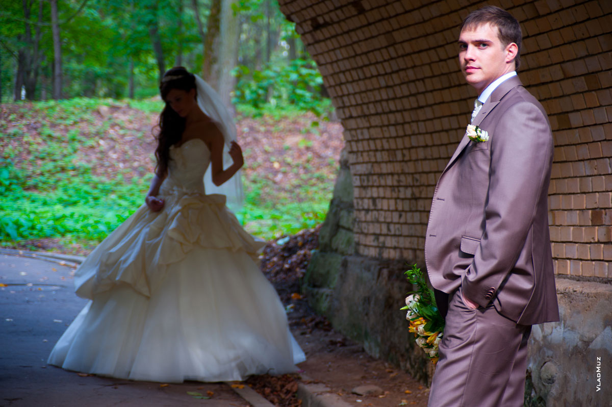 Фото жениха в фокусе, вдали невеста в тени в расфокусе
