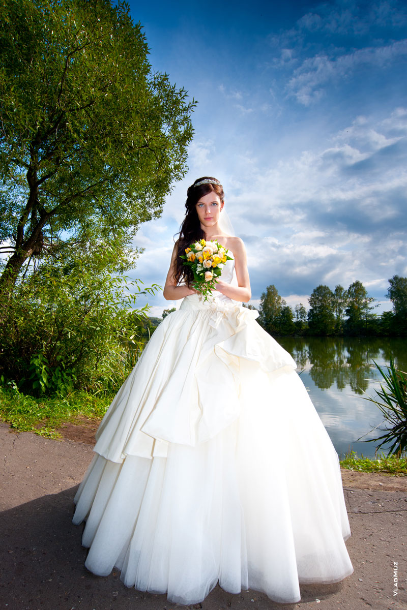 Фото невесты в очень большом свадебном платье на набережной старого русла Москвы-реки в Архангельском в Московской области