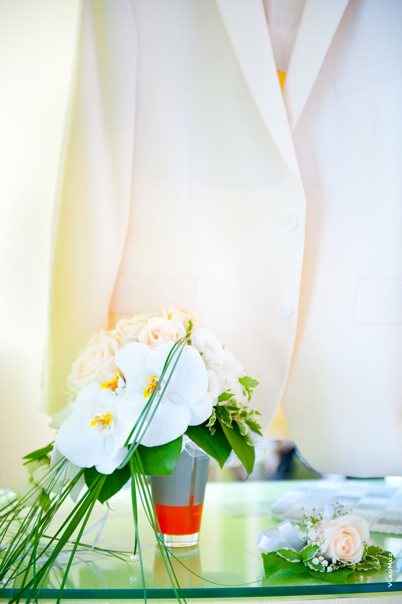Свадебный фото натюрморт: букет невесты, белый костюм и бутоньерка жениха