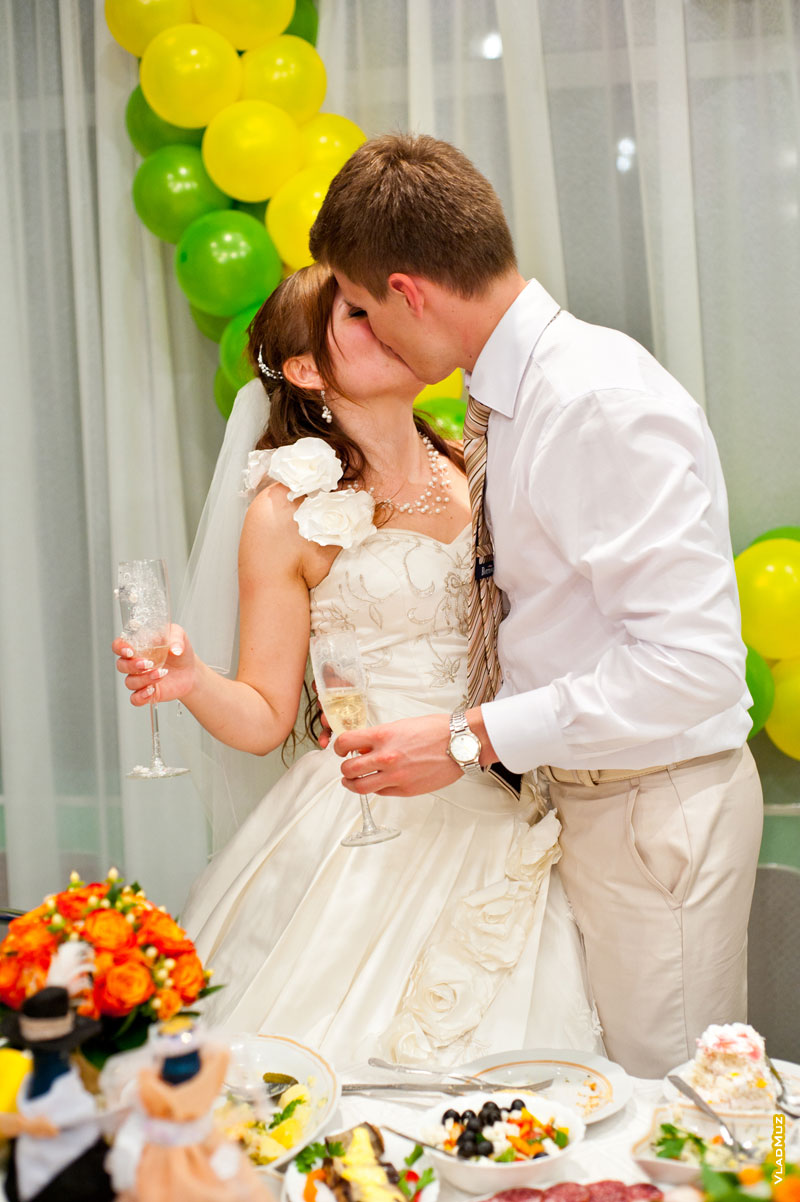 Свадебный поцелуй молодоженов в конце праздничного вечера