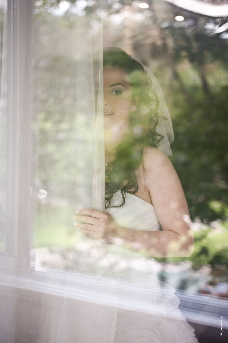 Фото невесты за стеклом у шторы