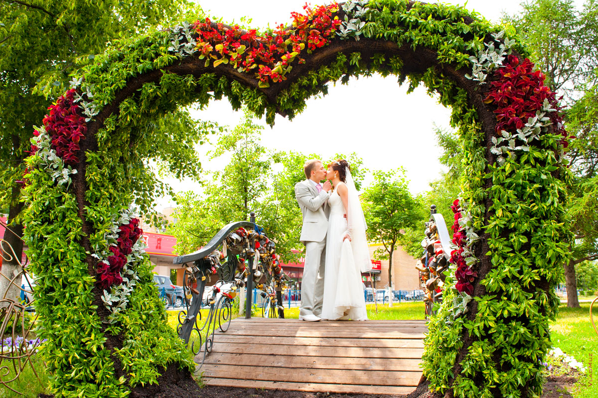 Фото поцелуя жениха и невесты в центре сердечной композиции на проспекте Королева