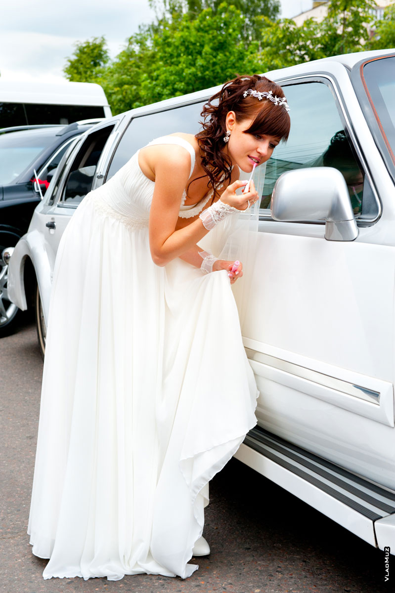 Фото девушки в свадебном платье в полный рост перед зеркалом