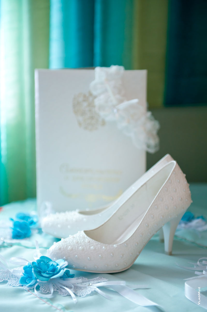 Фото белых туфель невесты, свидетельства о регистрации брака вдали и подвязки невесты