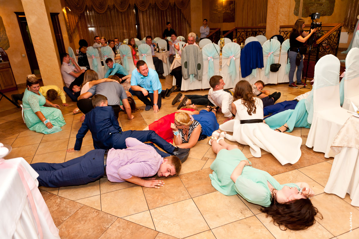 Фото гостей на свадьбе, лежащих на полу в ресторане во время свадебного конкурса